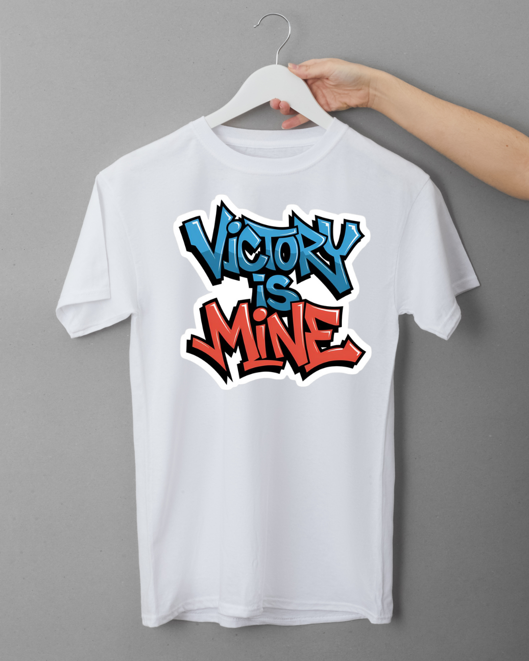 White t-shirt with 'Victory is Mine' text on a hanger against a gray background