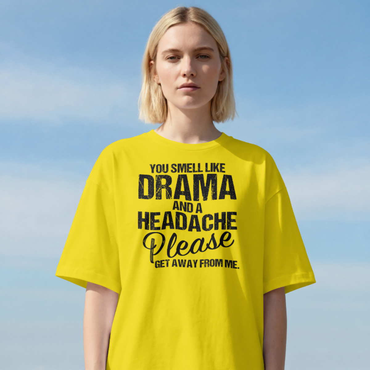 Person wearing a yellow t-shirt with text against a blue sky