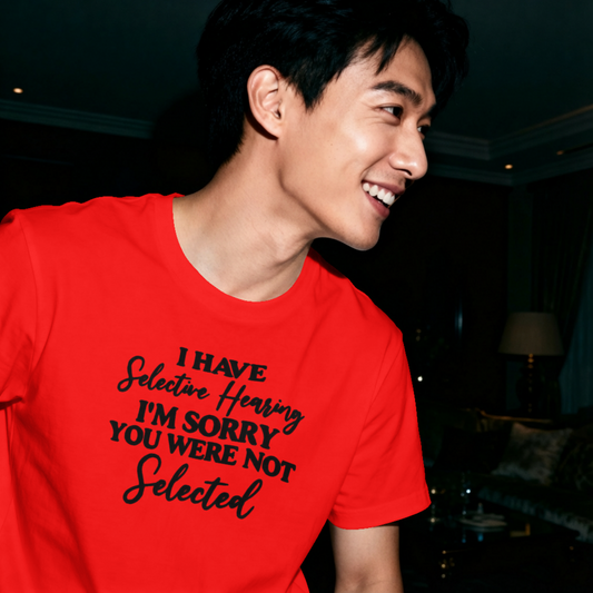 Person wearing a red t-shirt with humorous text in a dimly lit room.