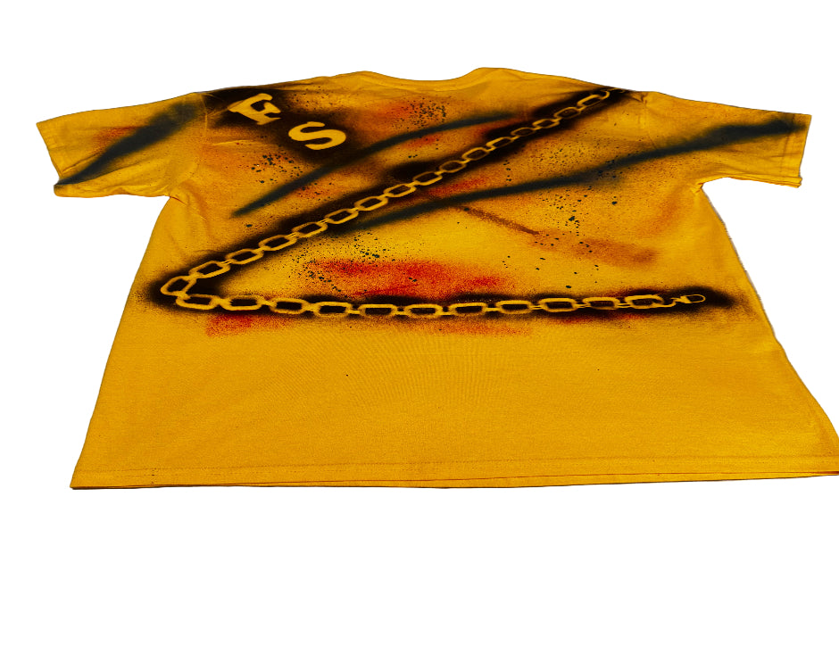 Yellow t-shirt with black chain design and red stains on a gray surface