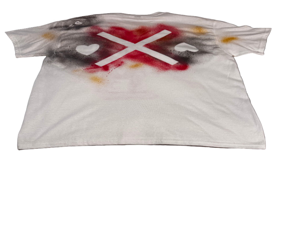 White t-shirt with red and black paint splashes on a gray surface