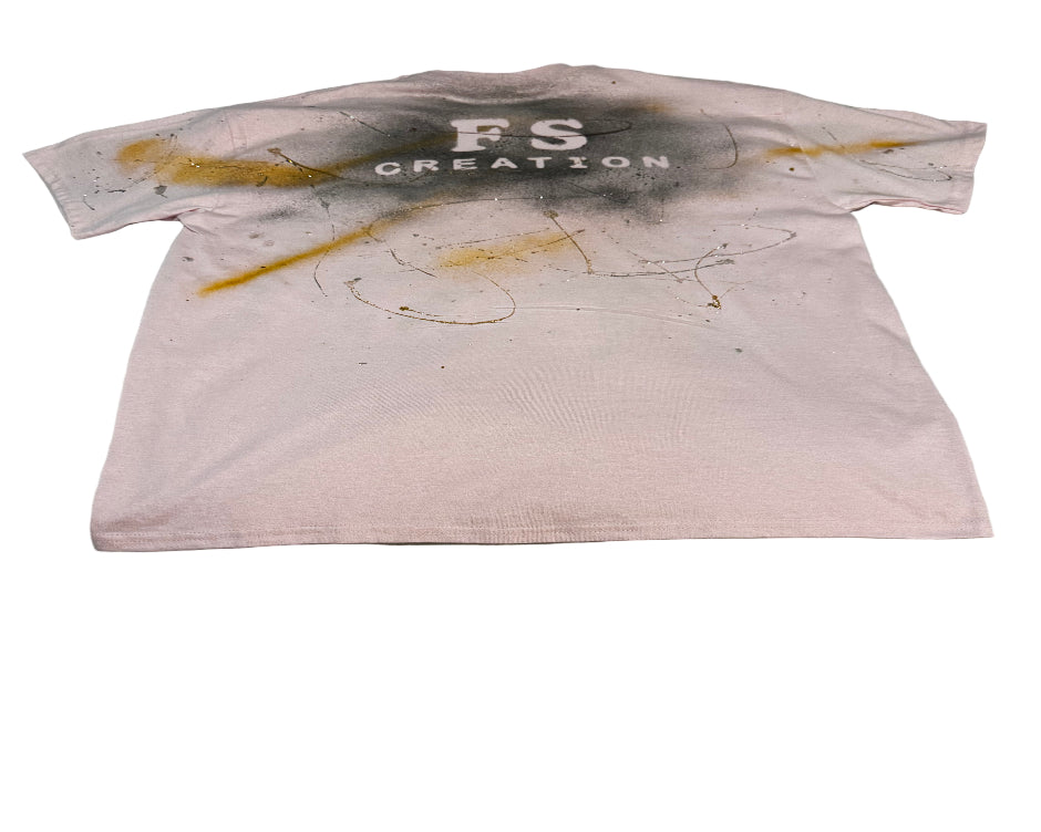 White t-shirt with yellow and black stains on a textured surface