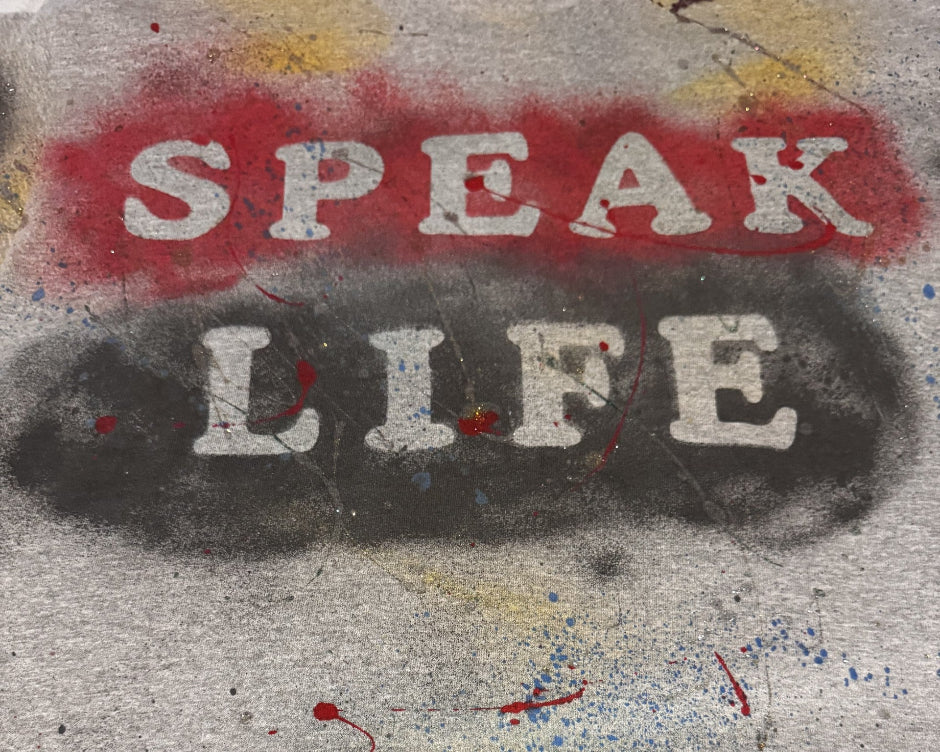 Street art with 'SPEAK LIFE' on a textured surface