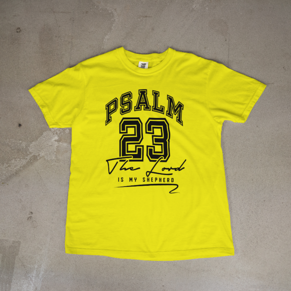 Yellow t-shirt with 'Psalm 23' text on a concrete floor