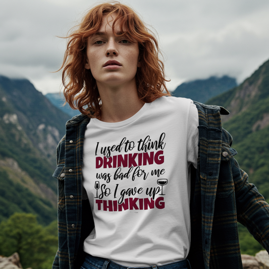 Person wearing a white t-shirt with humorous text in a mountainous landscape