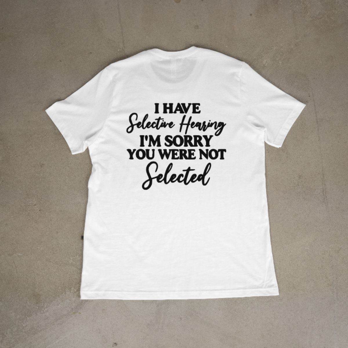 White t-shirt with humorous text on a beige background