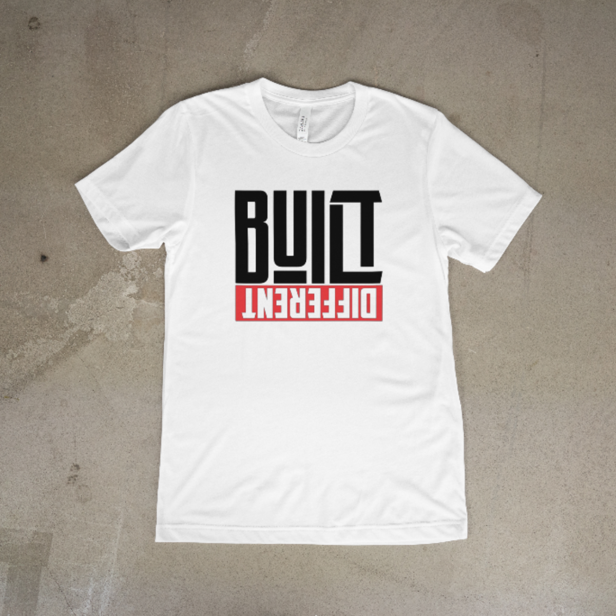 White t-shirt with 'Built Different' text on a textured gray background