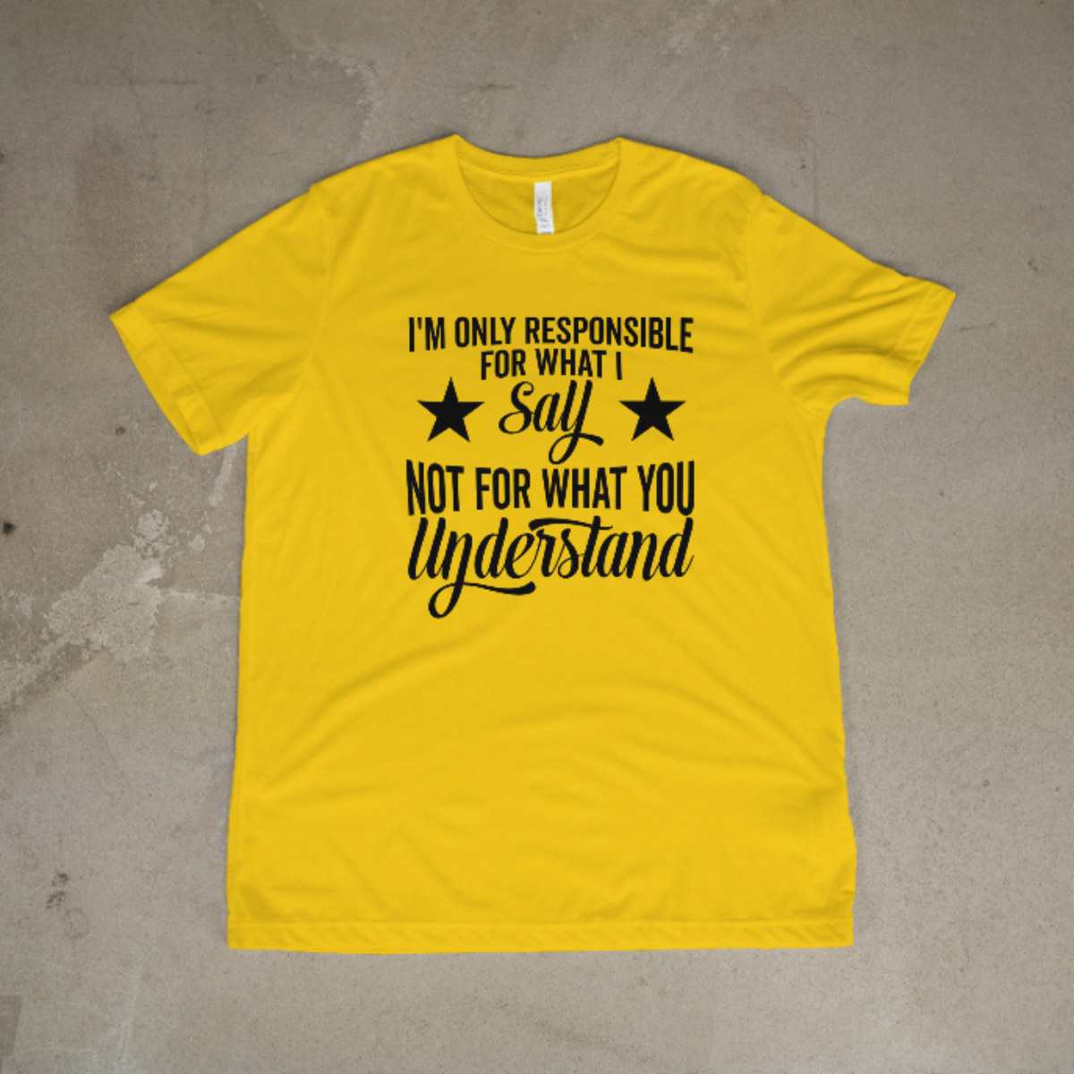 Yellow t-shirt with black text on a concrete floor