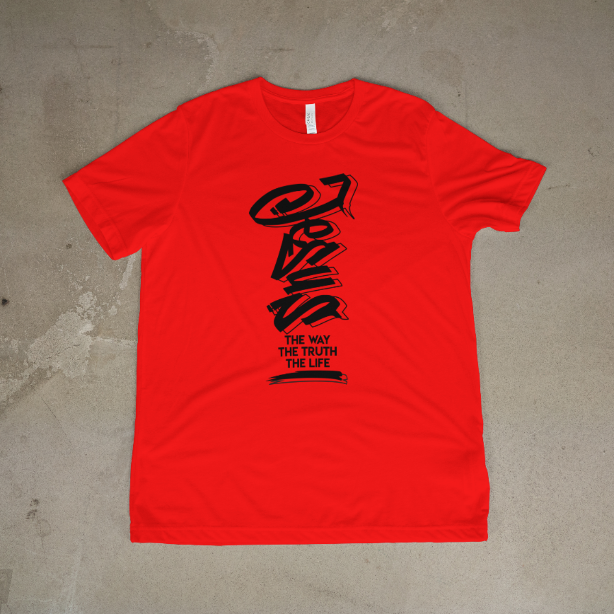 Red t-shirt with black graphic design on a concrete floor