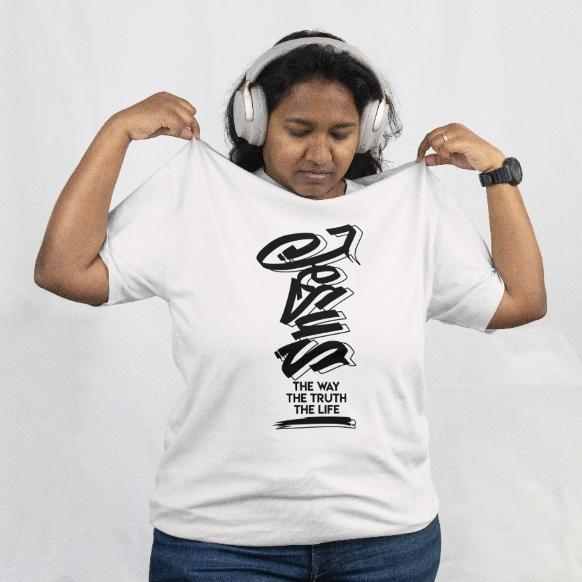 Person wearing a white t-shirt with black text and graphics, holding it up to show the design.