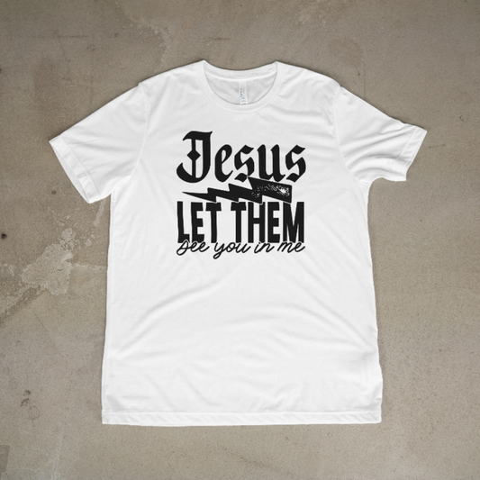 White t-shirt with black text 'Jesus let them see you in me' on a beige background