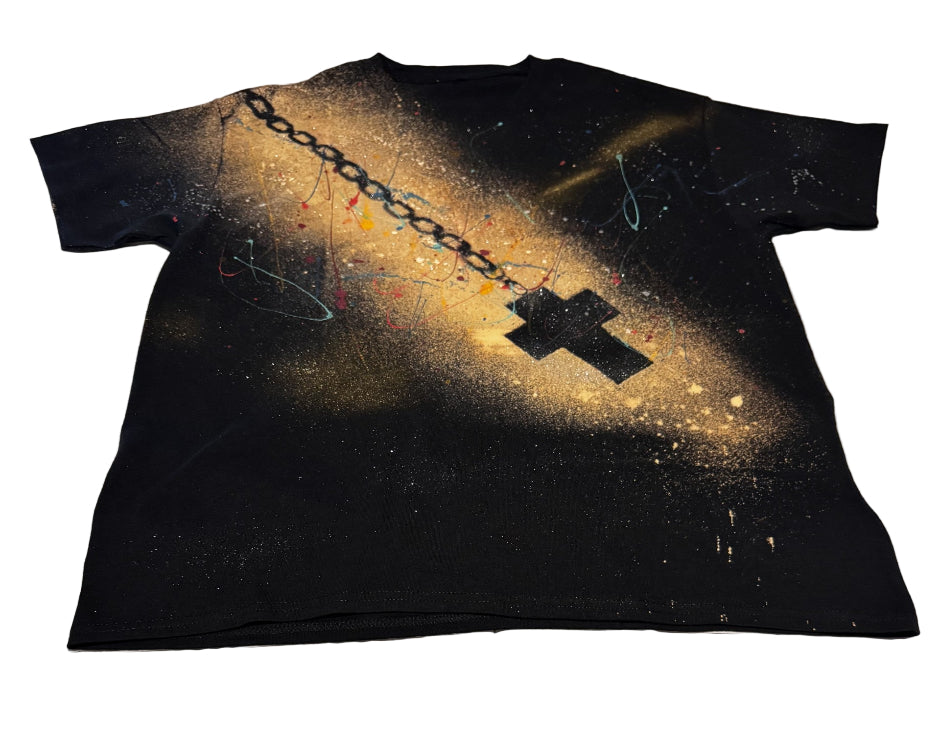 Black t-shirt with a chain and cross design on a white bedspread