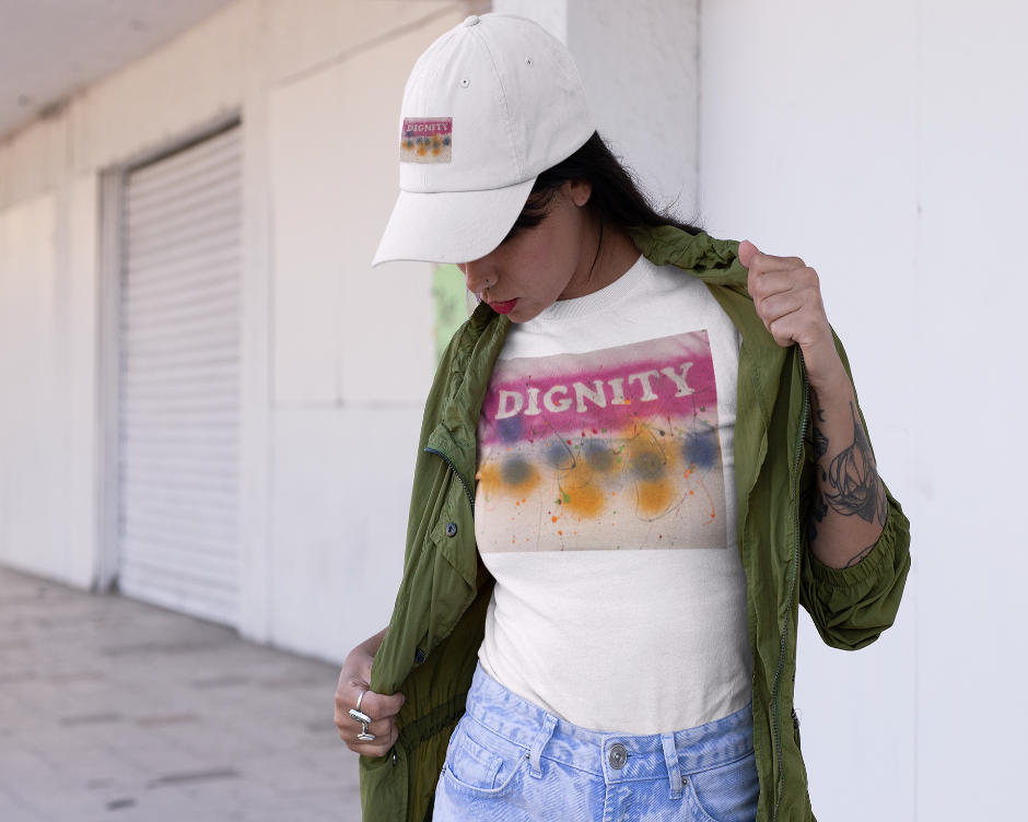 Person wearing a white t-shirt with 'DIGNITY' text and colorful design, green jacket, and white cap.