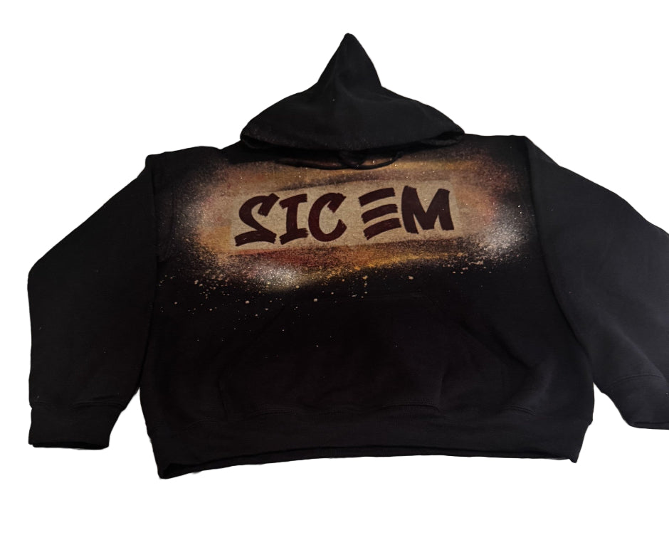 Black hoodie with 'SIC EM' text on the back, laid flat on a bed.