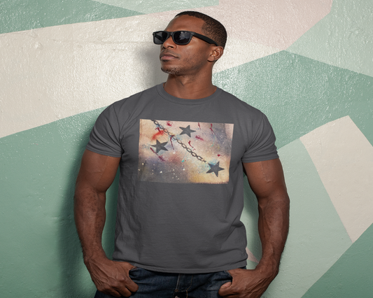 Man wearing a gray t-shirt with a graphic design against a geometric-patterned wall.